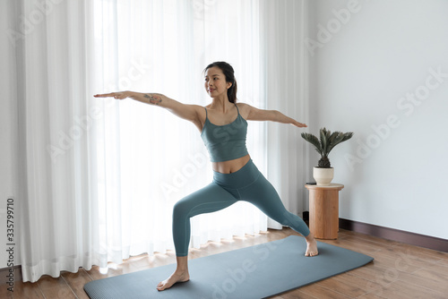 A young Asian woman doing yoga at home