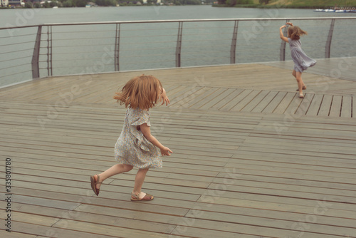 little girl runs on a wooden bridge