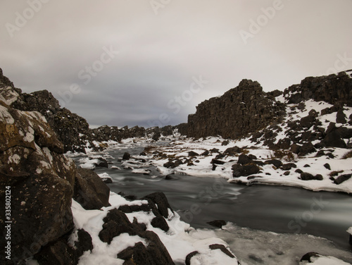 Ein kleiner Fluß zwischen schneebedeckten Felsen photo