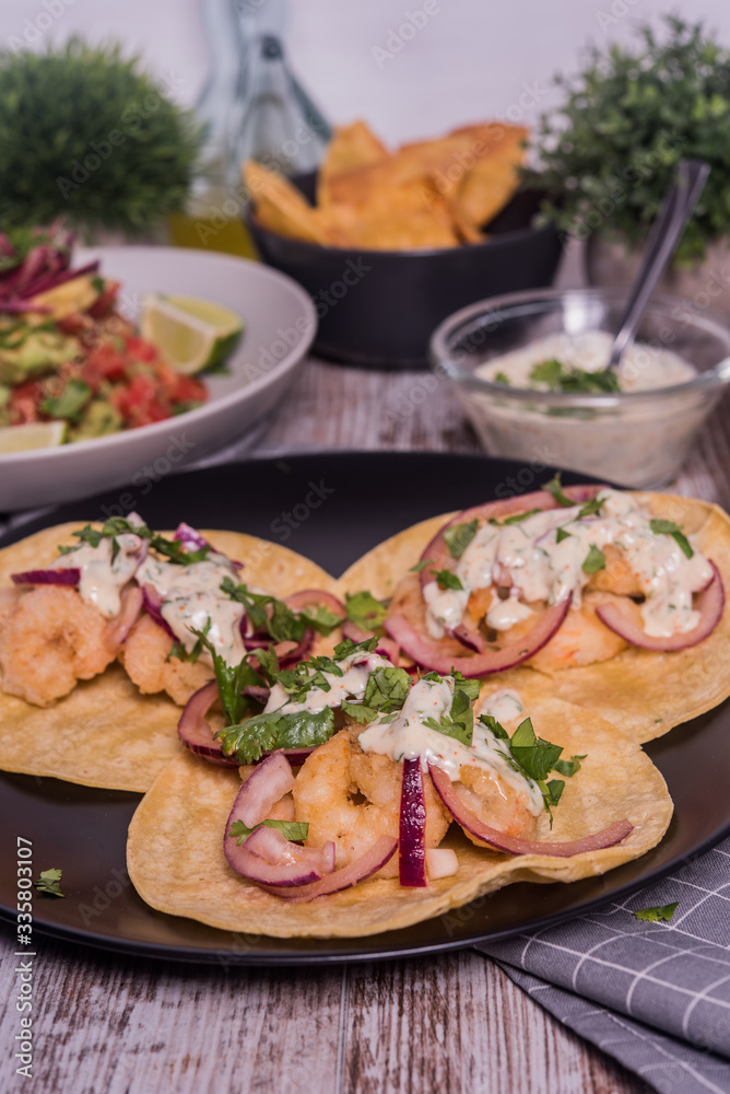 Tacos de langostinos con pico de gallo, cebolla roja incurtida y mayonesa de cilantro picante