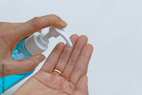 Fotografie Female fingers pumping alcohol-based hand sanitizer gel on hand for killing germs, bacteria and virus