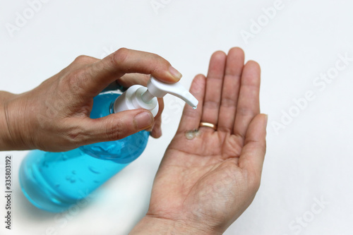 Female fingers pumping alcohol-based hand sanitizer gel on hand for killing germs  bacteria and virus. Disinfection concept of cleaning and washing hands with alcohol sanitizer.