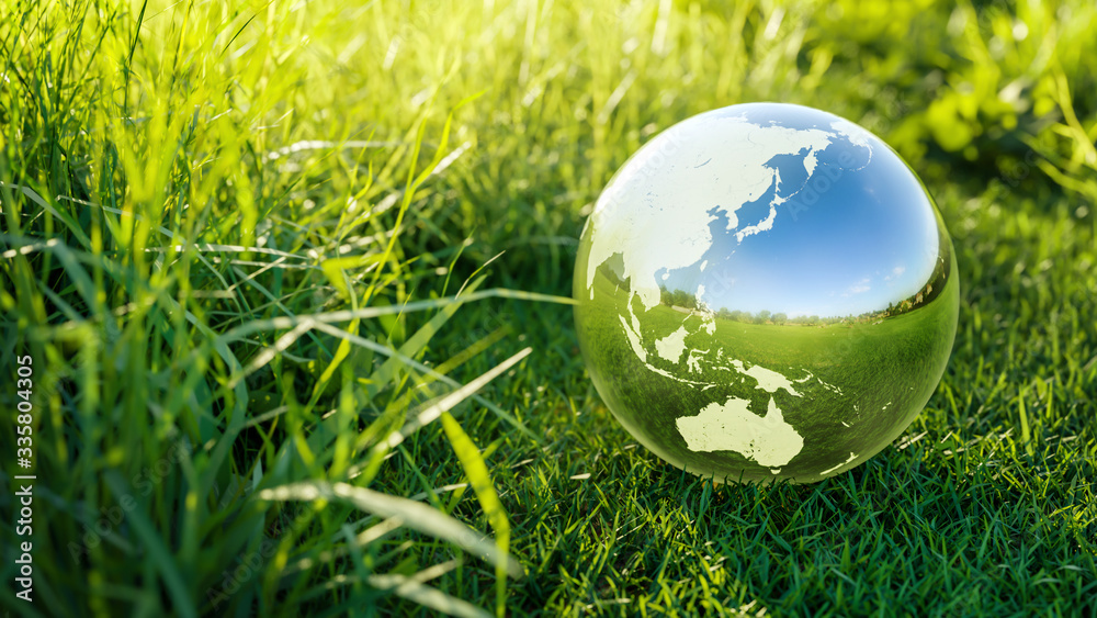 Planet Earth crystal ball on a green grass field Environmental protection, ecology and crystal ball of the world. Concept of ecology Protection. 3D rendering Planet Earth crystal ball on a green grass field Environmental protection, ecology and crystal ball of the world. Concept of ecology Protection. 3D rendering