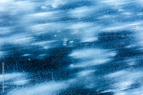 Snow frozen inside the ice on a lake as wind blows