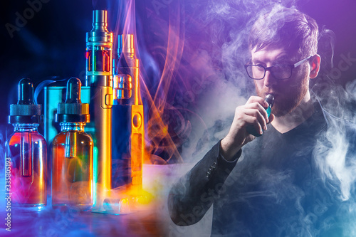 Collage on the topic of vaping. Focused man with e-cigarette and accessories for Smoking e-cigarettes. Vapes and liquids on a dark background with smoke. photo