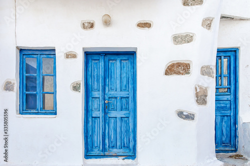 Fototapeta Naklejka Na Ścianę i Meble -  The facade of an old traditional house with deep blue wooden door and window in Serifos island Cyclades Greece