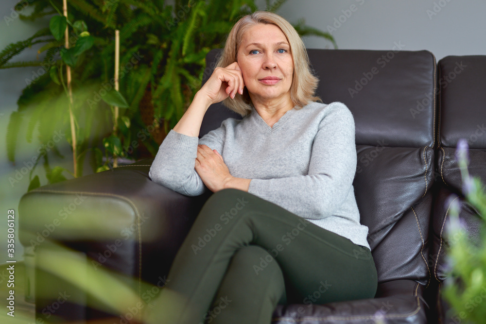 Happy woman relaxing on her couch at home in the sitting room. Happy woman relaxing on her couch at home in the sitting room.