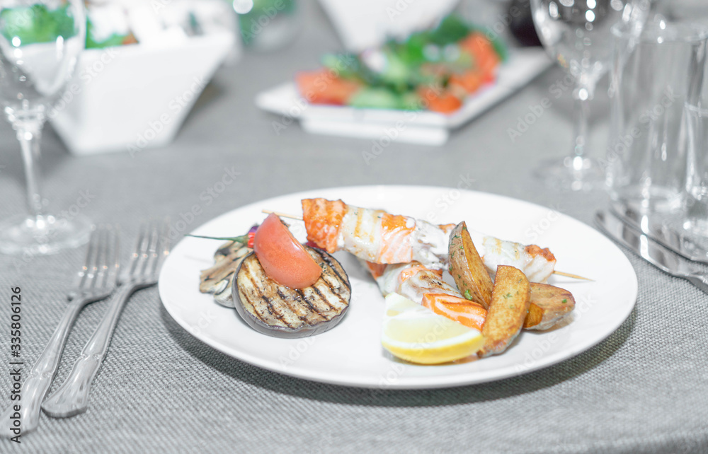 a dish of red fish on a white plate and on white dishes, haute cuisine