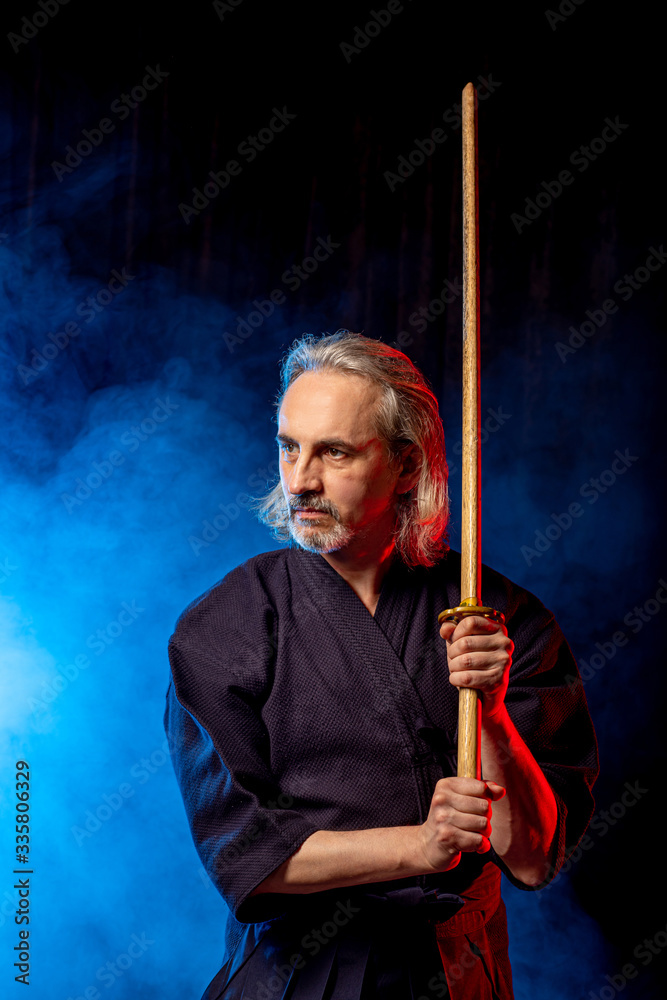 portrait of caucasian man kendo fighter with bokuto bamboo sword shinai . japanese traditional martial arts, protection, activity concept