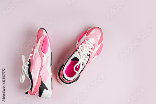 Fashion women's sneakers on a pink background. Female sport shoes.  Fitness concept. Top view, flat lay photo