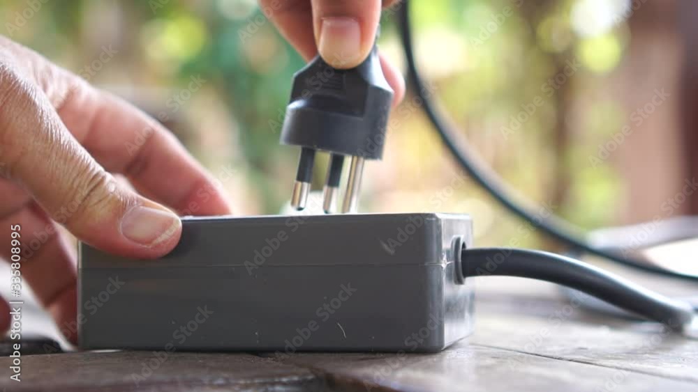 Hands putting socket electricity plug to connect electric multisocket