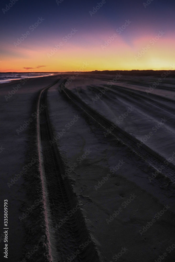 Samochodem po plaży o zachodzie słońca
