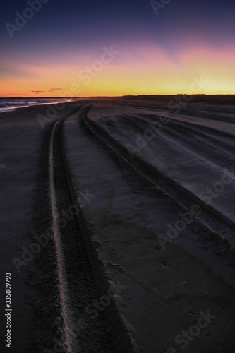 Samochodem po plaży o zachodzie słońca