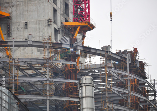 Construction site for the construction of a high-rise building in Shanghai, China. The red scaffolding is attached to the core of the building.