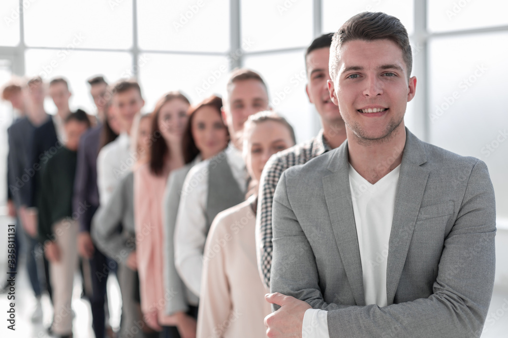 confident guy standing in line of diverse young people