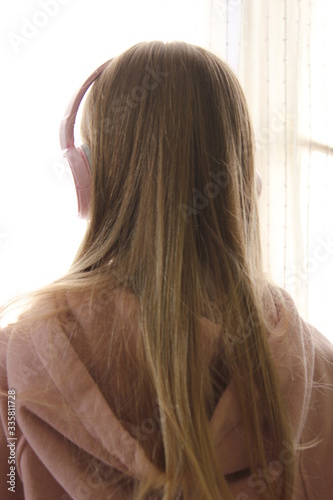 ragazza bionda con cuffie audio di colore rosa 