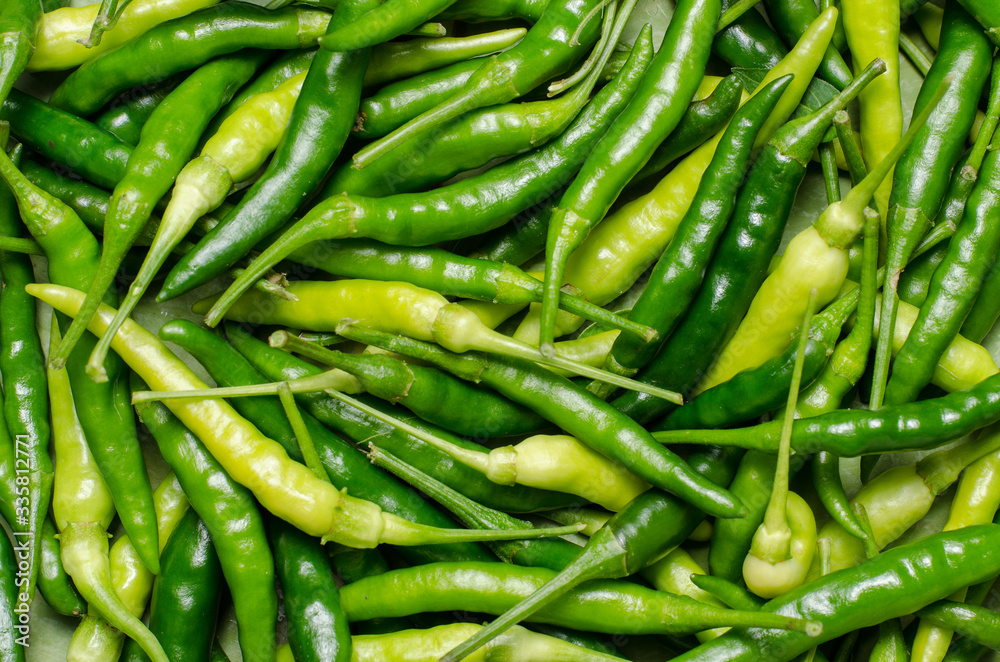 Close up top view of unripe green chilli background