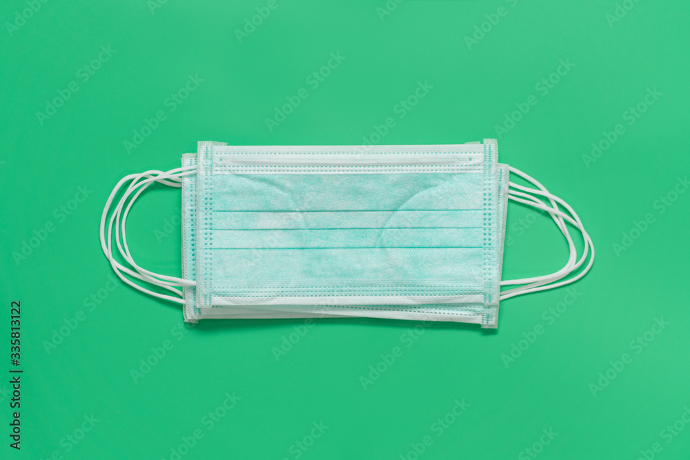 Blue Face mask on green background, Corona virus protection concept Blue Face mask on green background, Corona virus protection concept