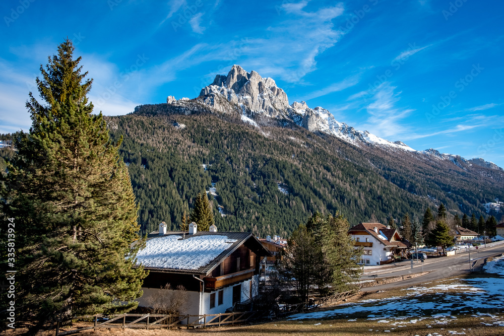 Typical italian house in south tyrol against the background of the forest and mountains in Vigo di Fassa, a commune in Trentino at the northern Italia. Val di Fassa, Dolomiti