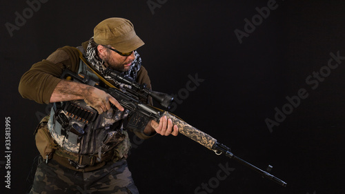 Soldier mercenary with a sniper rifle on a dark background