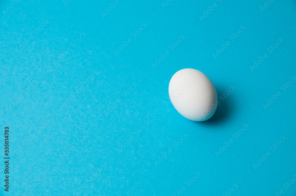 One white egg on a blue background. The concept of calorie content, life, healthy nutrition, Easter One white egg on a blue background. The concept of calorie content, life, healthy nutrition, Easter
