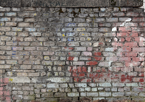The brickwork of the old wall, uneven bricks and protruding mortar, sometimes destroyed.