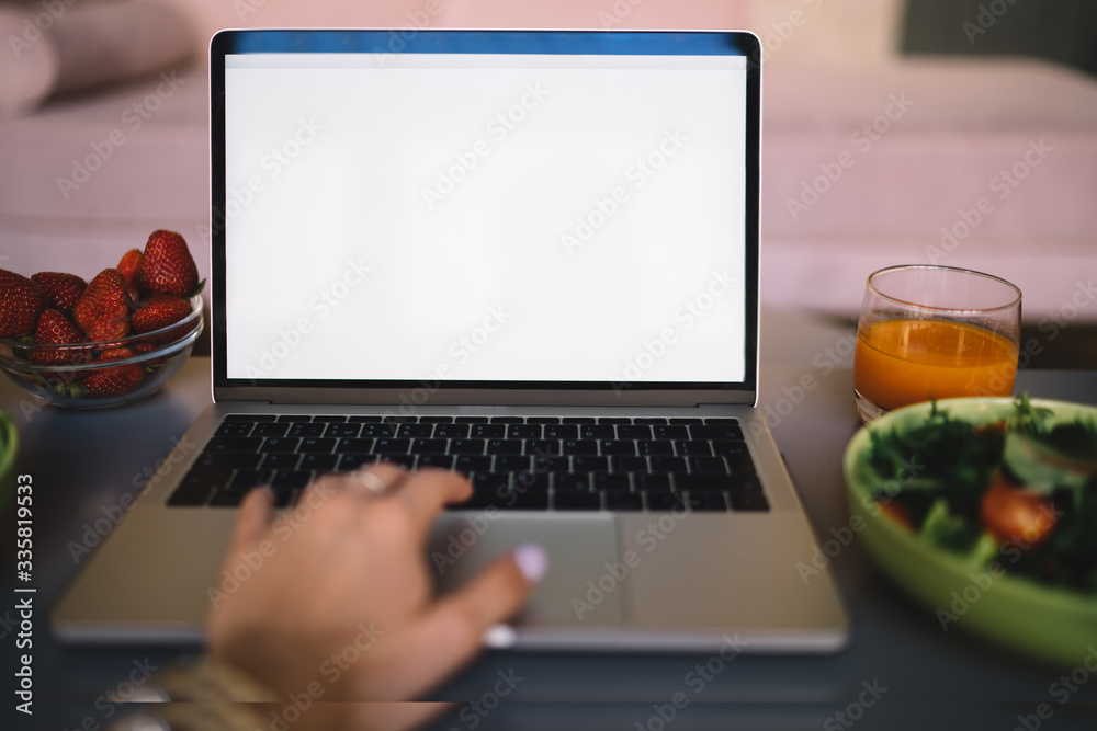 Woman surfing laptop while having meal at home