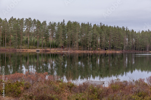 Autumn landscape. Sweden. Lake, calm water, forest reflection in the water clouds