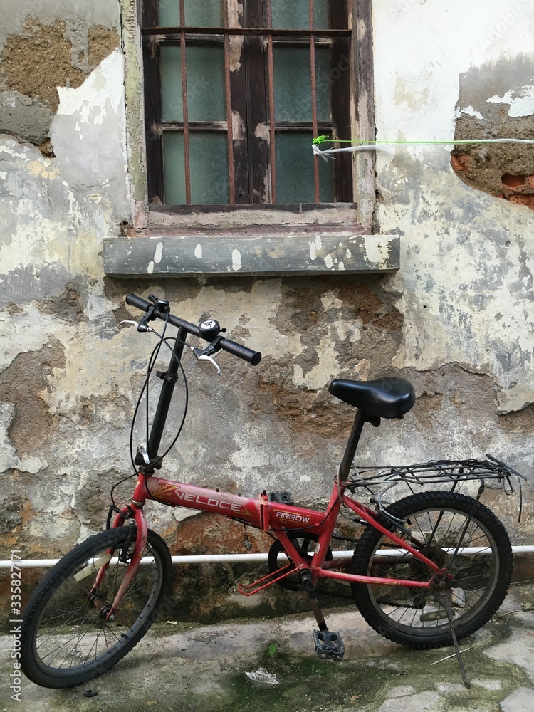 old bicycle in front of an old brick wall
