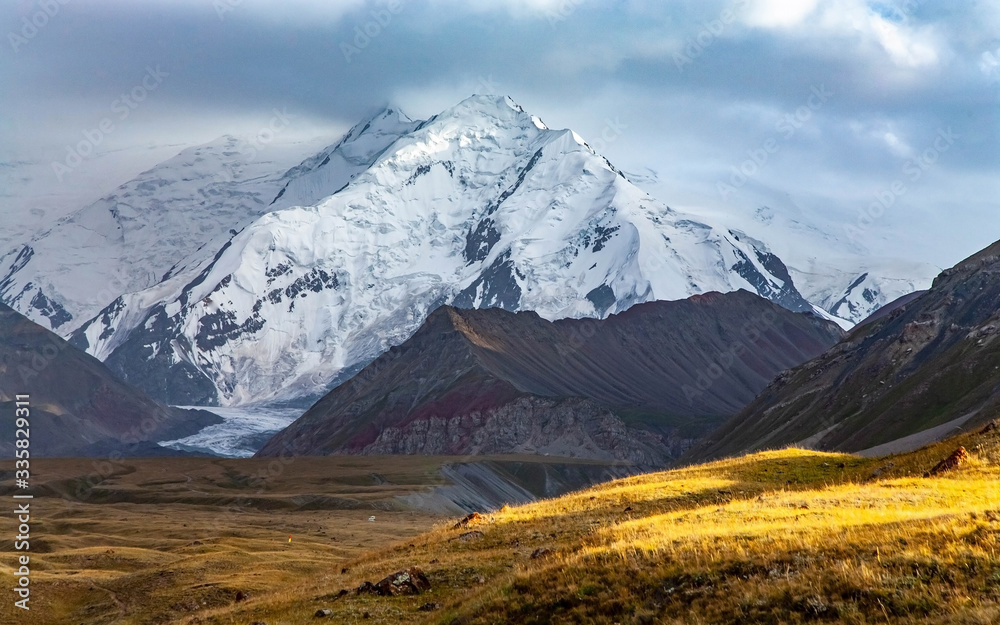 Fototapeta premium Scenic summer landscape of snowy mountain in Kyrgyzstan. The Trans-Alay Range. Pamir Mountain System. Cloudy day.