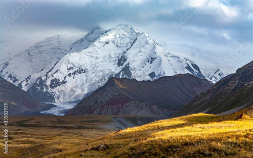 Scenic summer landscape of snowy mountain in Kyrgyzstan. The Trans-Alay Range. Pamir Mountain System. Cloudy day.