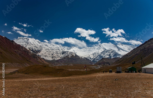Scenic summer landscape of snowy mountain in Kyrgyzstan. The Trans-Alay Range. Pamir Mountain System. Camp.