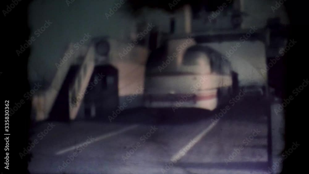 A bus enters the ship. Film runs through an 8mm projector