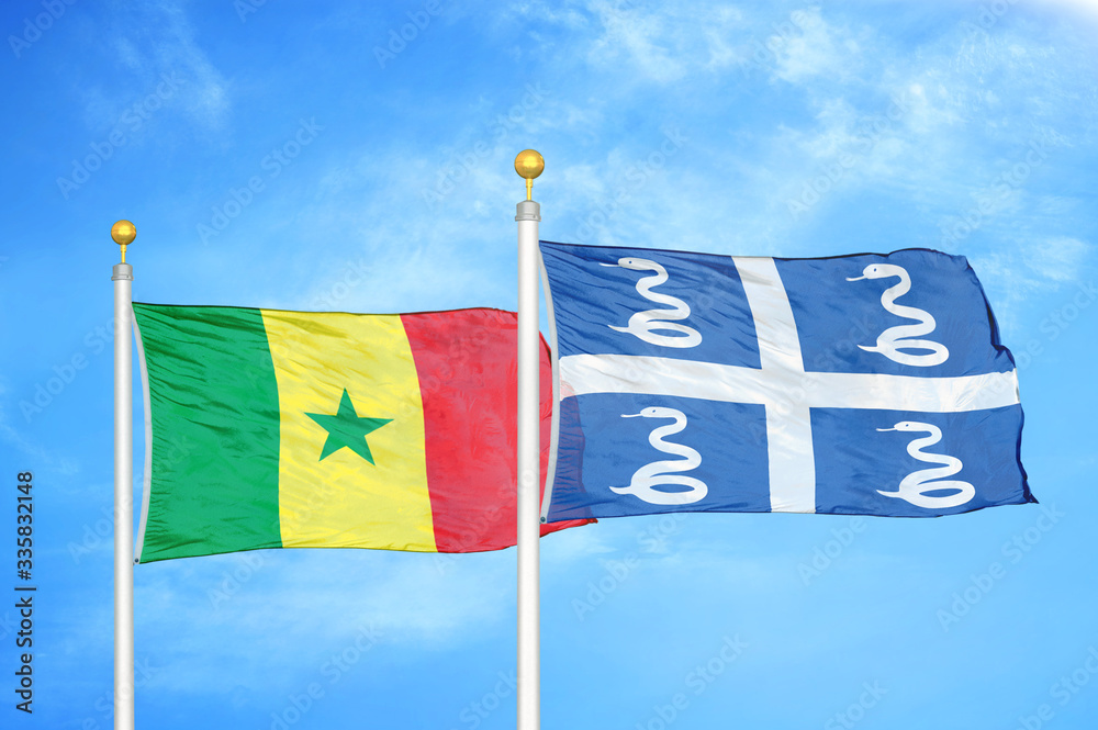 Fototapeta premium Senegal and Martinique snake two flags on flagpoles and blue cloudy sky