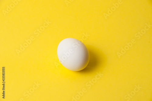 Chicken egg on a bright yellow background, copy space