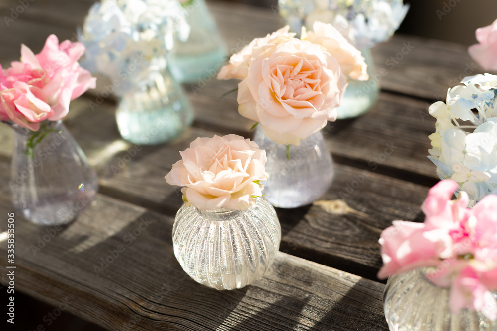 Decoration of blooming blue hydrangea, sweet pea Lathyrus, bush roses in small crystal vases on wooden background. Design,creative.International Women's Day,March 8 and Valentine's Day,14 of February Decoration of blooming blue hydrangea, sweet pea Lathyrus, bush roses in small crystal vases on wooden background. Design,creative.International Women's Day,March 8 and Valentine's Day,14 of February