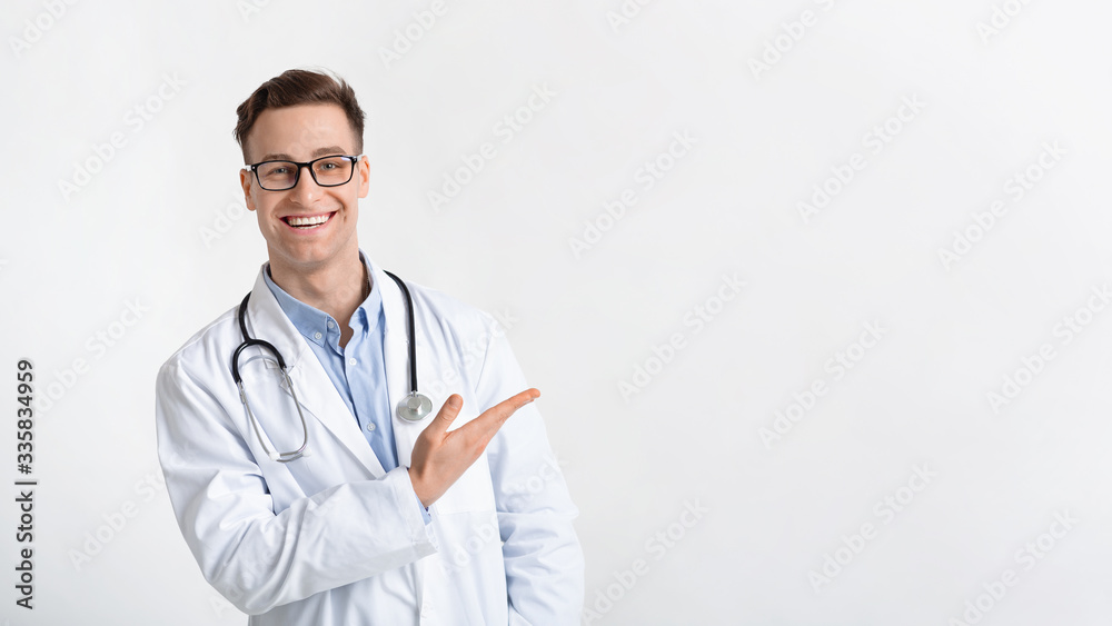 Smiling doctor in coat points to free place Smiling doctor in coat points to free place