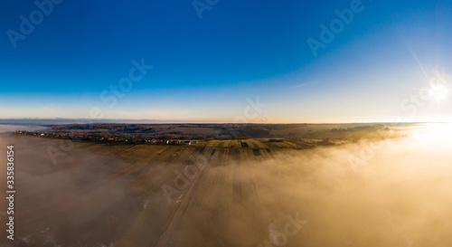 Beautiful panorama of winter village covered with dense fog from aerial view