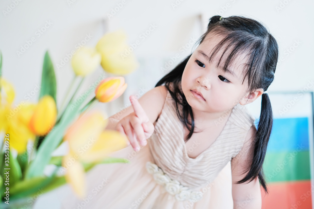 cute asian little girl playing with tulip flowers with interest having fun feeling happy and enjoying play time, staying at home exploring making using imagination, learning doing practical activities cute asian little girl playing with tulip flowers with interest having fun feeling happy and enjoying play time, staying at home exploring making using imagination, learning doing practical activities