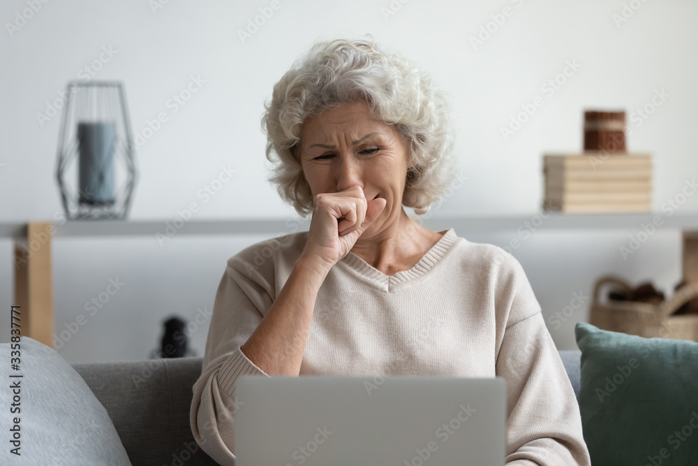 Front view depressed senior older woman crying, looking at computer screen. Stressed worried middle aged mature grandmother grieving, received bad message notification, sitting alone at home. Front view depressed senior older woman crying, looking at computer screen. Stressed worried middle aged mature grandmother grieving, received bad message notification, sitting alone at home.