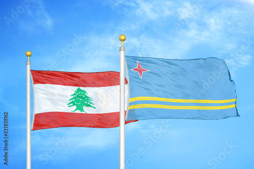 Lebanon and Aruba two flags on flagpoles and blue cloudy sky photo