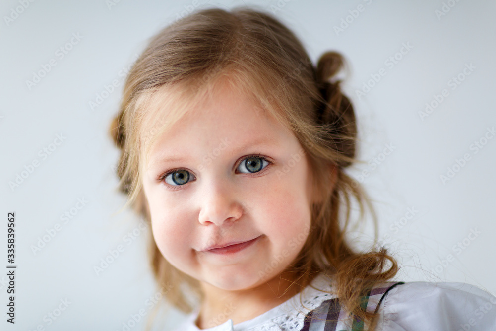 Portrait of a beautiful white cute girl with big eyes, looking at the camera and smiling beautiful child Portrait of a beautiful white cute girl with big eyes, looking at the camera and smiling beautiful child