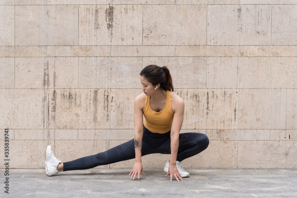 Fototapeta premium A young Asian woman is doing warm-up exercises