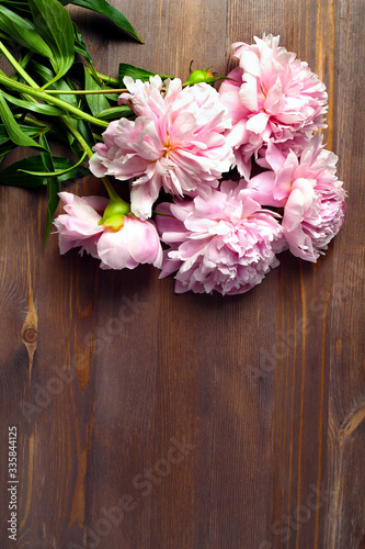 light pink color peony flowers bouquet on wood table. with copy space for your text top view and flat lay style. vertical frame