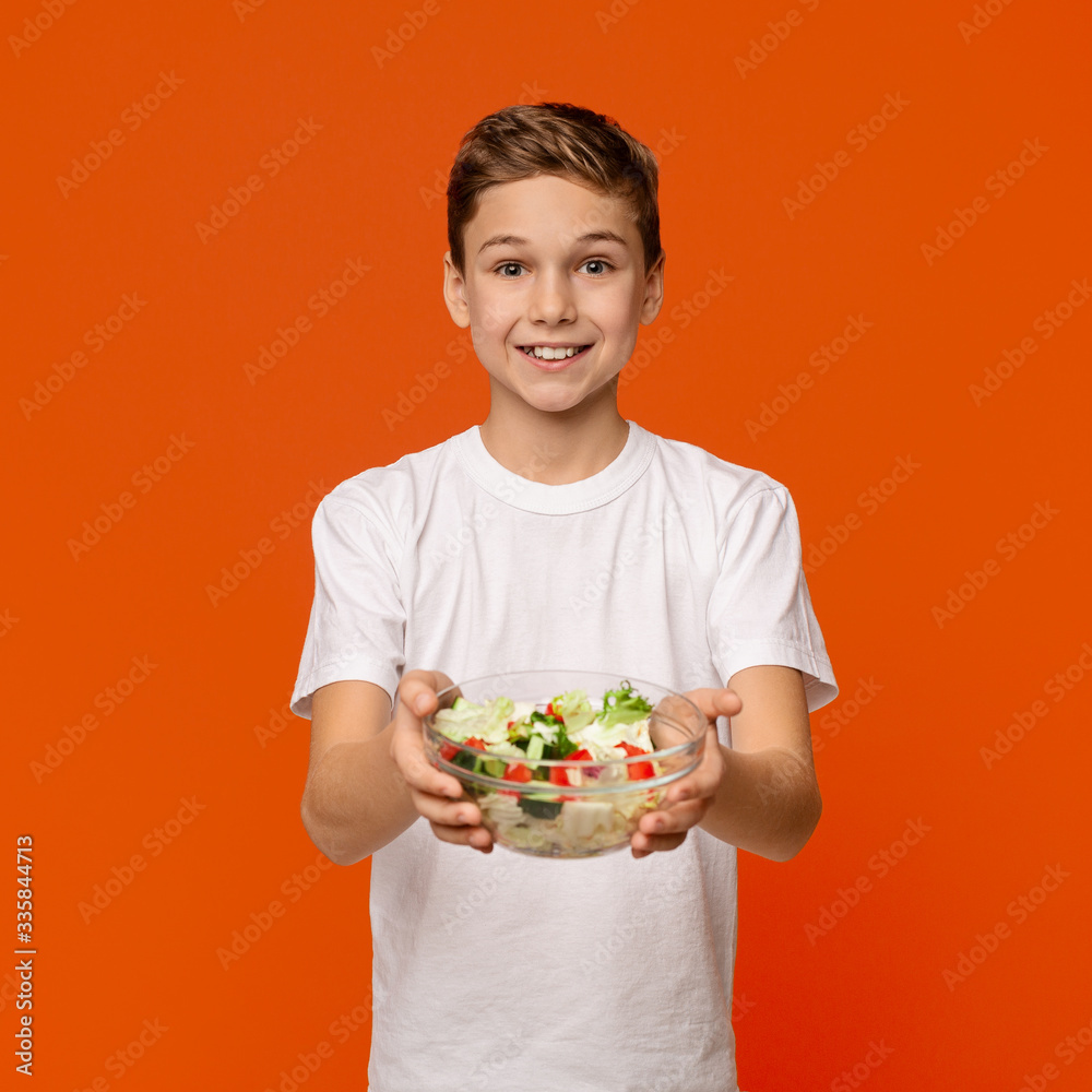 Teen boy sharing fresh vegetable salad on camera Teen boy sharing fresh vegetable salad on camera