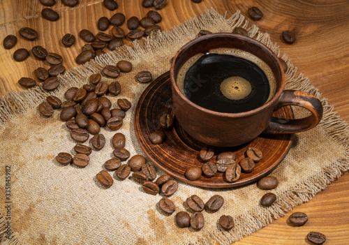 Coffee cup and coffee beans on old wooden background