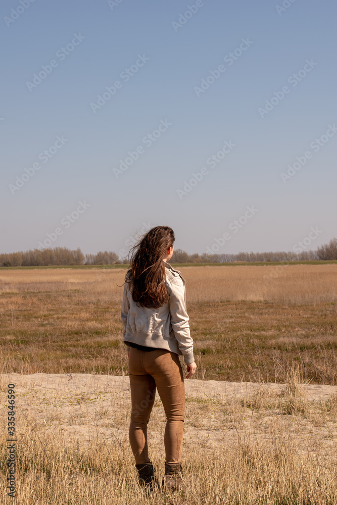 Beautiful young woman looks into the distance in nice weather