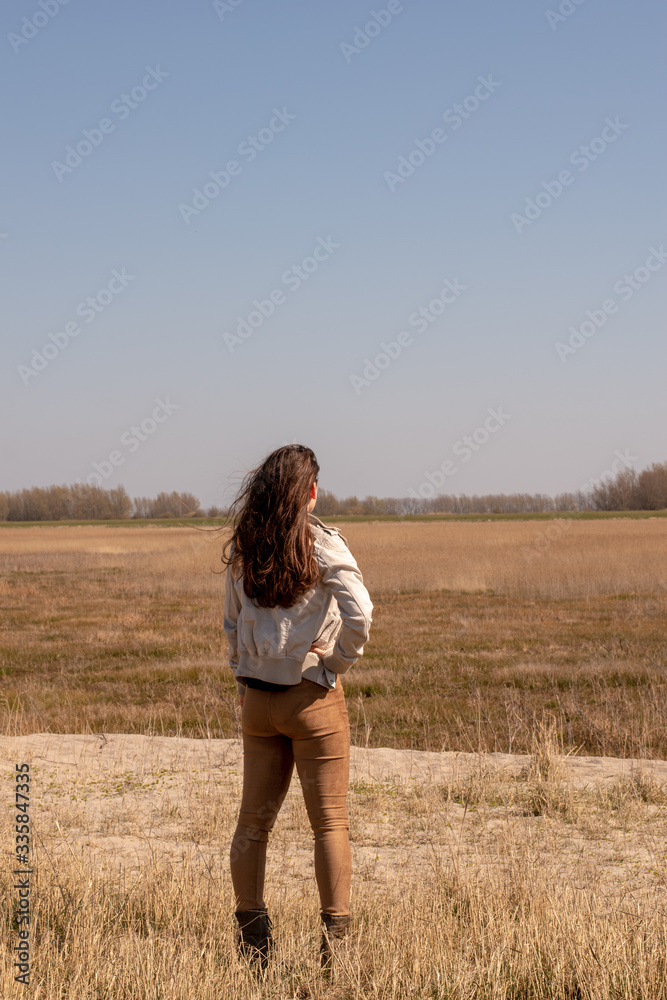 Beautiful young woman looks into the distance in nice weather Beautiful young woman looks into the distance in nice weather