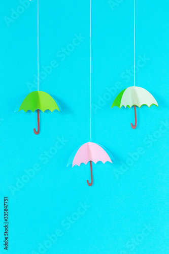 blue background with an umbrella on a rope of paper