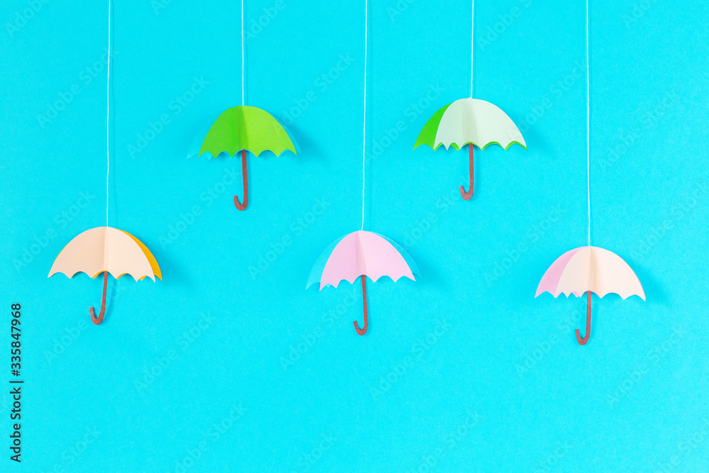 blue background with an umbrella on a rope of paper